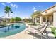 Serene backyard with a sparkling pool, spa, lounge chairs, and lush landscaping at 21141 E Stirrup St, Queen Creek, AZ 85142