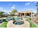 Inviting backyard pool area with a spa, lush landscaping, and patio seating at 21141 E Stirrup St, Queen Creek, AZ 85142
