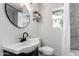 Bathroom view showcasing a round mirror, sink, toilet, and walk-in shower with curtain at 2161 E Corona Ave, Phoenix, AZ 85040
