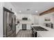Well-lit kitchen with stainless appliances, white cabinets, and a central island with a built-in cooktop at 2161 E Corona Ave, Phoenix, AZ 85040