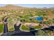 Scenic aerial view of a golf course with a pond, lush landscaping, and desert surroundings at 2544 W Pumpkin Ridge Dr, Anthem, AZ 85086