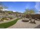 Paver patio featuring a fire pit, cactus, and desert landscaping creates a peaceful outdoor living space at 2544 W Pumpkin Ridge Dr, Anthem, AZ 85086