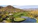 Expansive golf course view featuring a lush green fairway, sand traps, a tranquil lake, and scenic desert mountain backdrop at 2544 W Pumpkin Ridge Dr, Anthem, AZ 85086