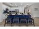 A modern kitchen featuring stainless steel appliances, white cabinets, a blue island, and bar stool seating at 2544 W Pumpkin Ridge Dr, Anthem, AZ 85086