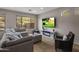 A cozy living room with comfortable seating, modern fireplace, and large window overlooking the backyard at 2544 W Pumpkin Ridge Dr, Anthem, AZ 85086