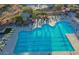 Aerial view of a community pool with lane markers, lounge chairs, and shaded seating areas at 2544 W Pumpkin Ridge Dr, Anthem, AZ 85086