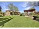 Expansive backyard with lush lawn, mature landscaping, and a charming pergola creating an inviting outdoor living space at 28689 N 67Th Dr, Peoria, AZ 85383