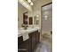 Bright bathroom with a dual sink vanity, wooden cabinets, and a separate shower and toilet room at 28689 N 67Th Dr, Peoria, AZ 85383
