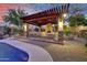 Inviting poolside patio with a pergola-covered outdoor dining area, perfect for entertaining with a built-in fireplace at 28689 N 67Th Dr, Peoria, AZ 85383
