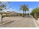Wrought iron security gate to community with paved entrance, desert landscaping, and palm trees at 3314 E Kael St, Mesa, AZ 85213