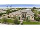 Stunning single-story home with meticulous landscaping, lush green lawn, and grand facade featuring a tiled roof and charming entryway at 3314 E Kael St, Mesa, AZ 85213