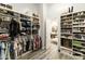Organized walk-in closet with clothing racks, shelves, and a view into the bright bathroom at 3314 E Kael St, Mesa, AZ 85213