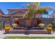Landscaped backyard features a brick water feature, colorful planters, and lush lawn at 3397 E Derringer Way, Gilbert, AZ 85297