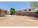 Large backyard featuring brick fireplace, mature trees, and block wall creating a private outdoor space at 3397 E Derringer Way, Gilbert, AZ 85297