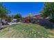 Expansive backyard featuring a covered patio, fire pit, lush lawn, and mature trees at 3397 E Derringer Way, Gilbert, AZ 85297