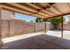 Covered backyard patio area with a concrete slab and block wall, offering a relaxing outdoor space at 3397 E Derringer Way, Gilbert, AZ 85297