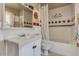 Bathroom with vintage style bathtub and shower combo, a sink with vanity, and classic black-and-white tile accents at 3397 E Derringer Way, Gilbert, AZ 85297
