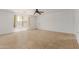 Bright, empty bedroom featuring neutral tile flooring, window, door, and a ceiling fan at 3397 E Derringer Way, Gilbert, AZ 85297