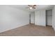 Bedroom with neutral carpet, ceiling fan, closet with sliding doors, and a doorway leading to an upper floor at 3397 E Derringer Way, Gilbert, AZ 85297