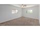 Bright bedroom featuring neutral carpet, ceiling fan, and two windows offering pleasant views and natural light at 3397 E Derringer Way, Gilbert, AZ 85297