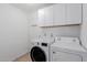 Clean laundry room with white cabinets, tiled floors, and modern appliances including a washer and dryer at 3397 E Derringer Way, Gilbert, AZ 85297