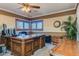 Home office featuring a large wooden desk, a ceiling fan, and a plant creating a warm and inviting workspace at 3397 E Derringer Way, Gilbert, AZ 85297