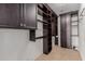 Spacious walk-in closet with custom dark wood cabinetry, shelving, and ample storage space for clothing and accessories at 3397 E Derringer Way, Gilbert, AZ 85297