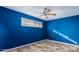 A bright blue bedroom with modern floors and a ceiling fan for added comfort at 346 E Highland Ave, Phoenix, AZ 85012