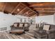 Open concept living room with fireplace, wood beamed ceiling, and modern kitchen view at 346 E Highland Ave, Phoenix, AZ 85012