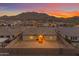 Backyard aerial view showcasing the property, fencing, patio, and mountain views at sunset at 3502 E Hazeltine Way, Queen Creek, AZ 85142