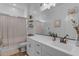 A modern bathroom with a spacious vanity, a framed mirror and a shower with neutral colored curtain at 3502 E Hazeltine Way, Queen Creek, AZ 85142