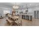 Open-concept dining area with a large wooden table and a full view of the modern white kitchen at 3502 E Hazeltine Way, Queen Creek, AZ 85142