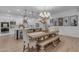 Open-concept dining area with a large wooden table and bench seating adjacent to the modern white kitchen at 3502 E Hazeltine Way, Queen Creek, AZ 85142
