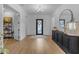 Spacious foyer with hardwood floors, a dark sideboard, a decorative mirror, and a view of the front door at 3502 E Hazeltine Way, Queen Creek, AZ 85142
