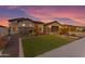 Well-maintained front yard with desert landscaping, a green lawn, and a paved driveway leading to a two-car garage at 3502 E Hazeltine Way, Queen Creek, AZ 85142