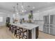 Modern white kitchen with stainless steel appliances, a large center island, and pendant lighting at 3502 E Hazeltine Way, Queen Creek, AZ 85142