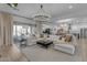 Bright living room showcasing an oversized sectional sofa, decorative chandelier and access to the outdoor space at 3502 E Hazeltine Way, Queen Creek, AZ 85142