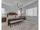 Cozy main bedroom with a chandelier, large bed, neutral colors, and natural light at 3502 E Hazeltine Way, Queen Creek, AZ 85142