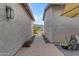 Narrow side yard featuring desert landscaping and a brick paver walkway between two stucco walls at 3502 E Hazeltine Way, Queen Creek, AZ 85142