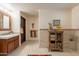Well-lit bathroom featuring a vanity, tiled accent wall, and rustic-style storage cabinet at 36601 N Mule Train Rd # B14, Carefree, AZ 85377