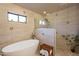 Bright bathroom featuring a modern soaking tub and glass-enclosed shower with decorative tiling at 36601 N Mule Train Rd # B14, Carefree, AZ 85377