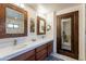 Bathroom featuring double vanity and mirrors with a doorway view of walk-in shower at 36601 N Mule Train Rd # B14, Carefree, AZ 85377