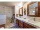 Bright bathroom featuring double sinks, modern vanity, and tiled walk-in shower at 36601 N Mule Train Rd # B14, Carefree, AZ 85377