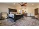 Bedroom with wooden floors, a ceiling fan, wooden furniture, a large mirror, and a decorative rug at 36601 N Mule Train Rd # B14, Carefree, AZ 85377