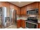 Bright kitchen with stainless steel appliances, wood cabinets, and tiled backsplash at 36601 N Mule Train Rd # B14, Carefree, AZ 85377