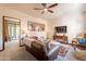 Comfortable living room with a ceiling fan, brown leather sofa, and view to enclosed porch at 36601 N Mule Train Rd # B14, Carefree, AZ 85377