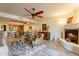 Open concept living room with a fireplace, ceiling fan, and dining area in the background at 36601 N Mule Train Rd # B14, Carefree, AZ 85377