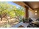 Outdoor covered patio with desert views, rocking chair and potted plants at 36601 N Mule Train Rd # B14, Carefree, AZ 85377
