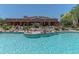 Community pool surrounded by desert landscaping, lounge seating and a covered building at 36601 N Mule Train Rd # B14, Carefree, AZ 85377