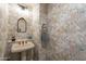 Charming powder room featuring unique wallpaper, a pedestal sink, and decorative mirror at 36601 N Mule Train Rd # B14, Carefree, AZ 85377